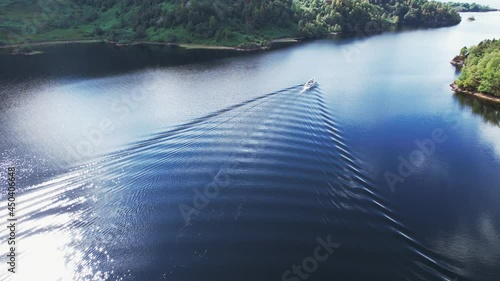 Aerial footage of a little passenger cruise ship on the beautiful Loch Katrine, in Central Scotland, on a bright summer’s day. 