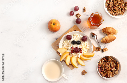 Healthy breakfast with ingredients, flat lay, fruit salad with muesli, apricots, grapes, honey and apple on a bright table. Healthy and natural food concept, lifestyle, top view,