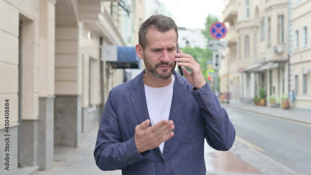 Man Talking on Phone Angrily while Walking Down the Street Man Talking on Phone Angrily while Walking Down the Street