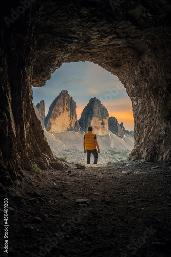 Three peaks of Tre Cime di Lavaredo captured from a cave during sunset