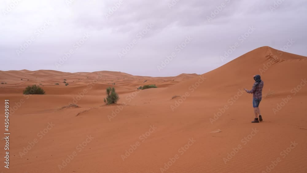 Isolated man is tries to find signal for his phone in Sahara Desert Isolated man is tries to find signal for his phone in Sahara Desert