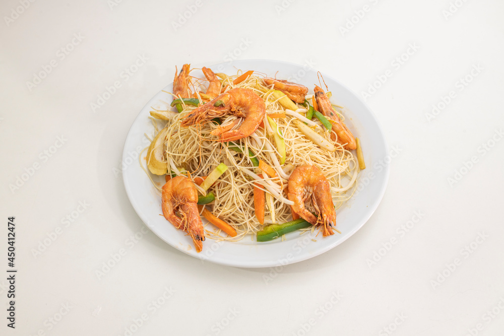Chinese rice noodles with fried prawns, bean sprouts and wok-sauteed vegetables on white plate Chinese rice noodles with fried prawns, bean sprouts and wok-sauteed vegetables on white plate