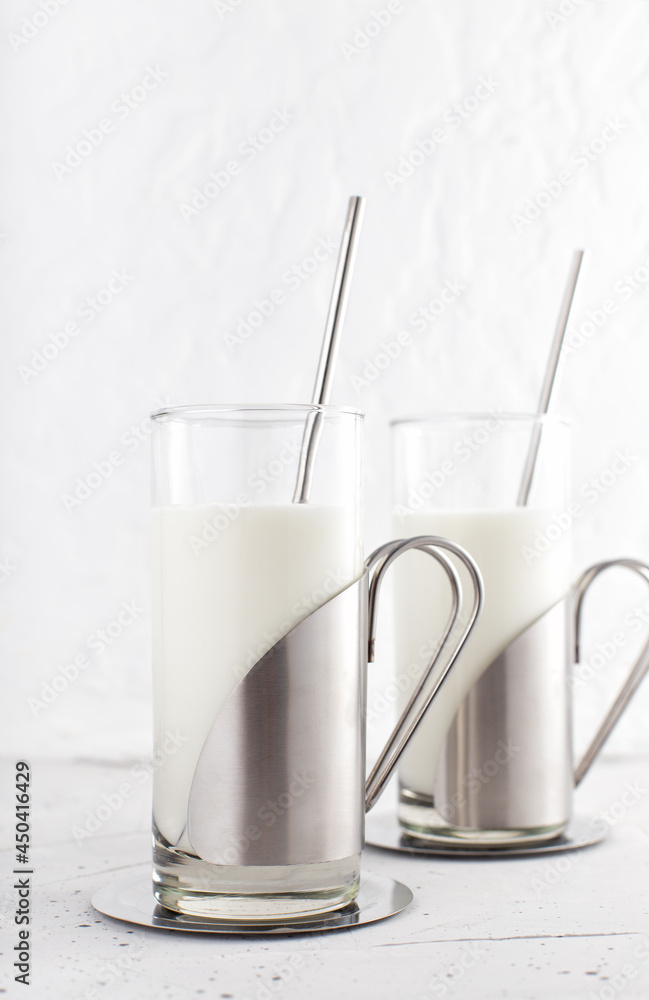 Traditional indian drink in glass with steel and metal straw. Lassi made from yogurt with water, spices and ice. Ayran or kefir in design cups Traditional indian drink in glass with steel and metal straw. Lassi made from yogurt with water, spices and ice. Ayran or kefir in design cups