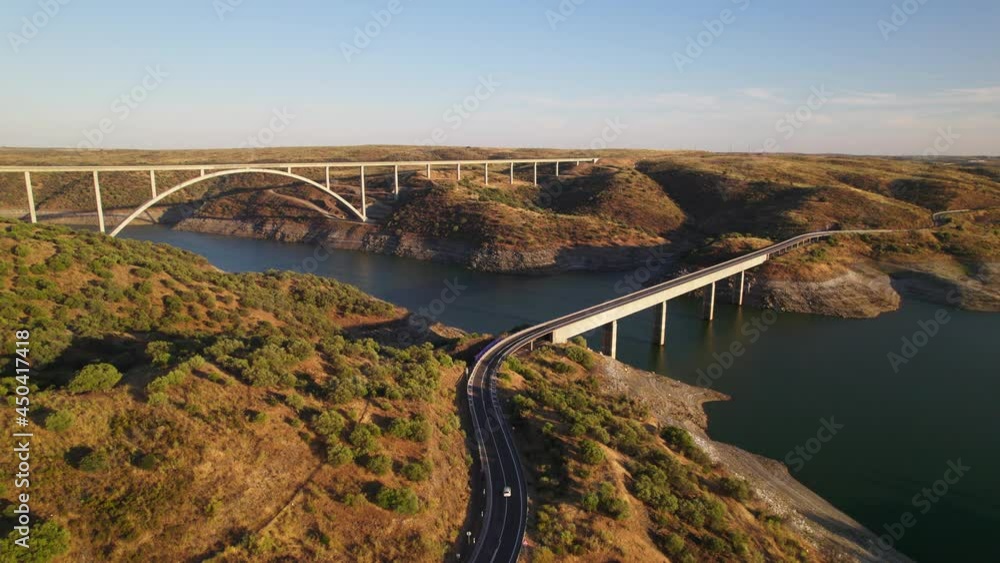 Long and high train and road bridges crossing Tajo river in Extremadura at sunset. Drone shot 