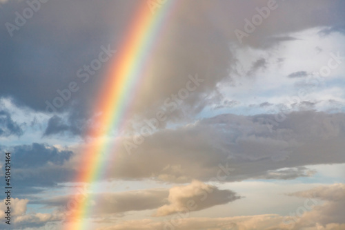 雨上がりの雲の晴れ間と空に架かる大きな虹の橋 © maruboland