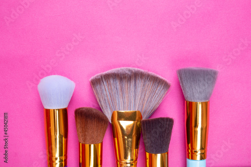 BROCHAS PARA MAQUILLAJE DORADAS SOBRE FONDO ROSA photo