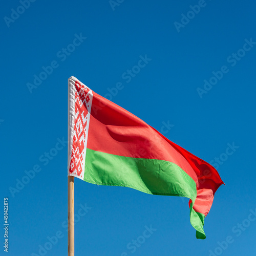 Waving flag of Belarus against the blue sky.