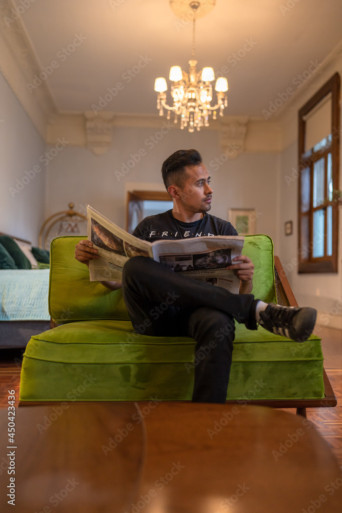 man sitting on sofa and reading a newspaper 