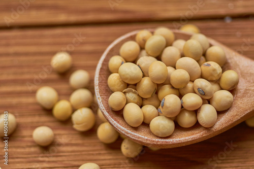 Macro shot of soybeans in wooden spoon. Vegan food concept