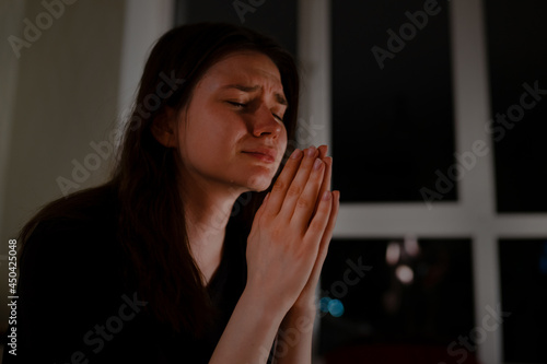 Photo Young woman praying and crying at night