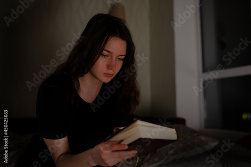 Woman reads the Bible at night