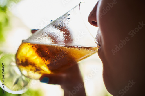 Unrecognizable woman drinking beer on a restaurant with views to nature