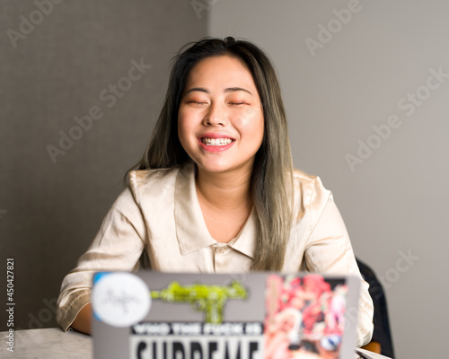 Young Asian Data Scientist Laughing at a Meeting