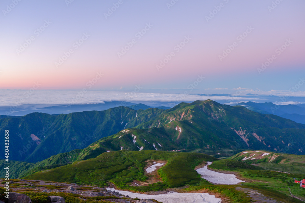 Fototapeta premium 日の出前の白山御前峰山頂から眺める別山までの雪渓の残る稜線（令和３年７月）