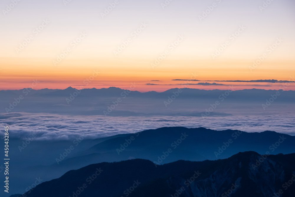 令和３年７月の白山御前峰から眺める日の出前の雲海に浮かぶ北アルプス連峰のシルエット