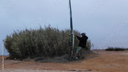 Slow motion of Portuguese windsurfer trying out his sail on a skate and going super fast! photo