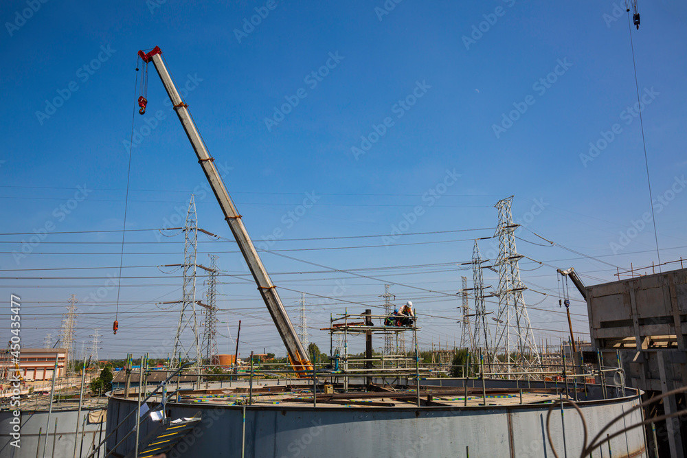 Tank construction site of oil and gas industrial power plant heavy crane lift construction