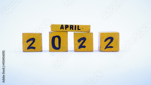Wooden block calendar for April 2022. Yellow on a white background