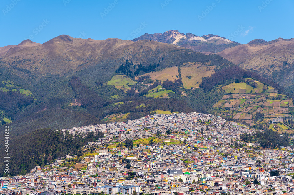 Quito city built on the active Pichincha volcano slopes and view over the highest peak, the Rucu Pichincha, Quito, Ecuador.