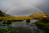 A rainbow at sunset above a pond near the Landmannalaugar hut and camping sites, Fjallabak Nature Reserve, Central Highlands, Iceland