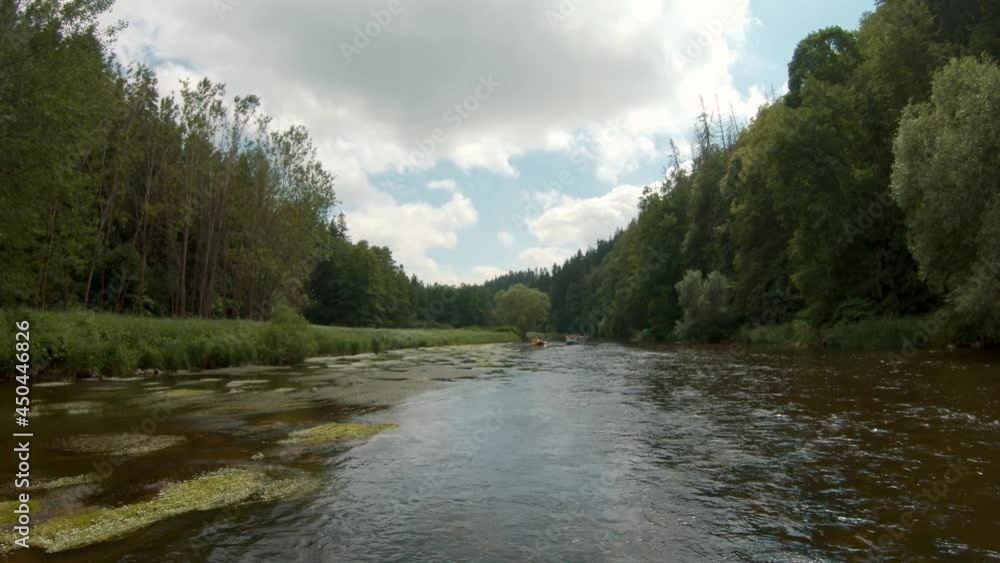 group of paddlers floating down the Vltava river surrounded by forests group of paddlers floating down the Vltava river surrounded by forests