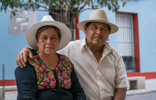 Latin couple of grandparents, sitting outdoors in colorful streets of Oaxaca, Mexico