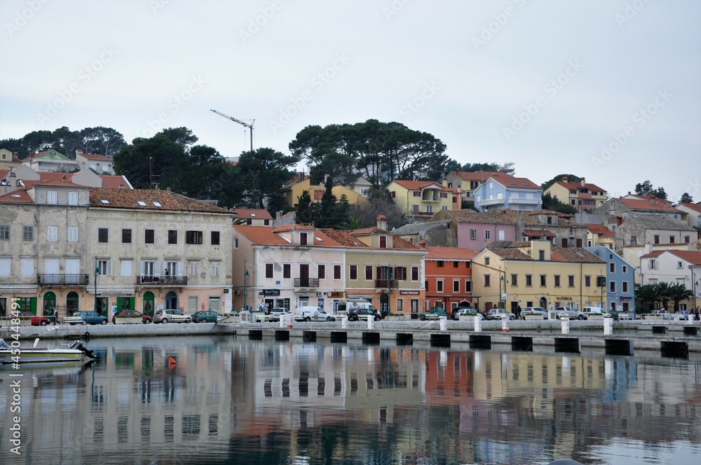 Panorama of the Mali Losinj city, reflections of houses on the sea. Mali Losinj coastline reflections on the sea.