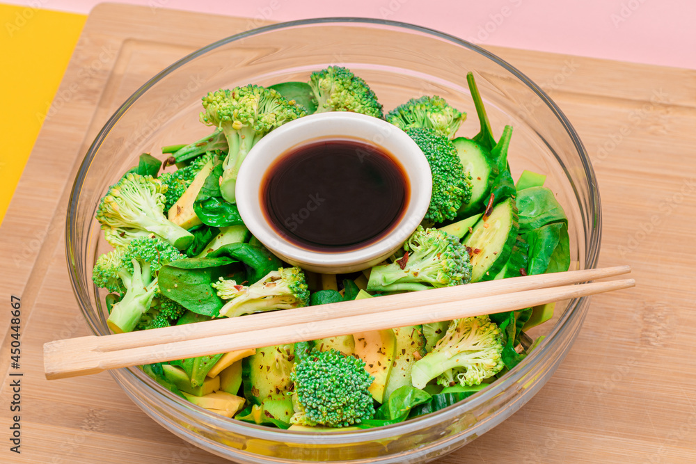 Fresh Green Salad of Avocado, Broccoli, Spinach and Cucumber for Detox with Soy Sauce on Wooden Cutting Board. Vegan Salad. Vegetarian Culture. Raw Food. Healthy Eating and Vegetable Diet Fresh Green Salad of Avocado, Broccoli, Spinach and Cucumber for Detox with Soy Sauce on Wooden Cutting Board. Vegan Salad. Vegetarian Culture. Raw Food. Healthy Eating and Vegetable Diet
