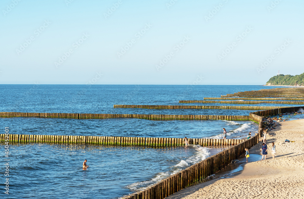 A breakwater made of logs cuts through the sea wave
