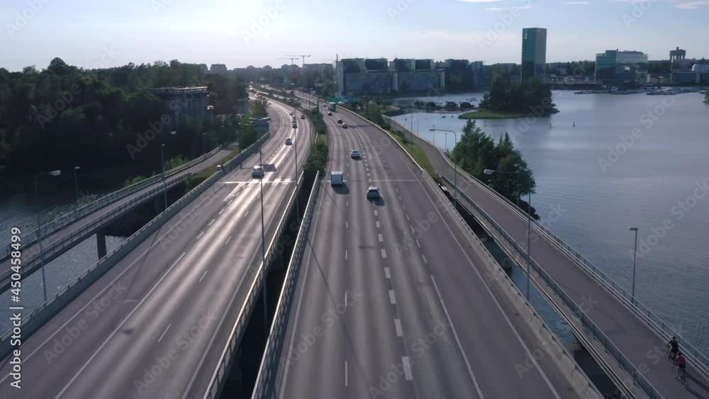 Helsinki.Finland-July 17.2019 The cars running through the bridge in Lauttasaari in Helsinki Finland with the trees on the side of the bridge Helsinki.Finland-July 17.2019 The cars running through the bridge in Lauttasaari in Helsinki Finland with the trees on the side of the bridge