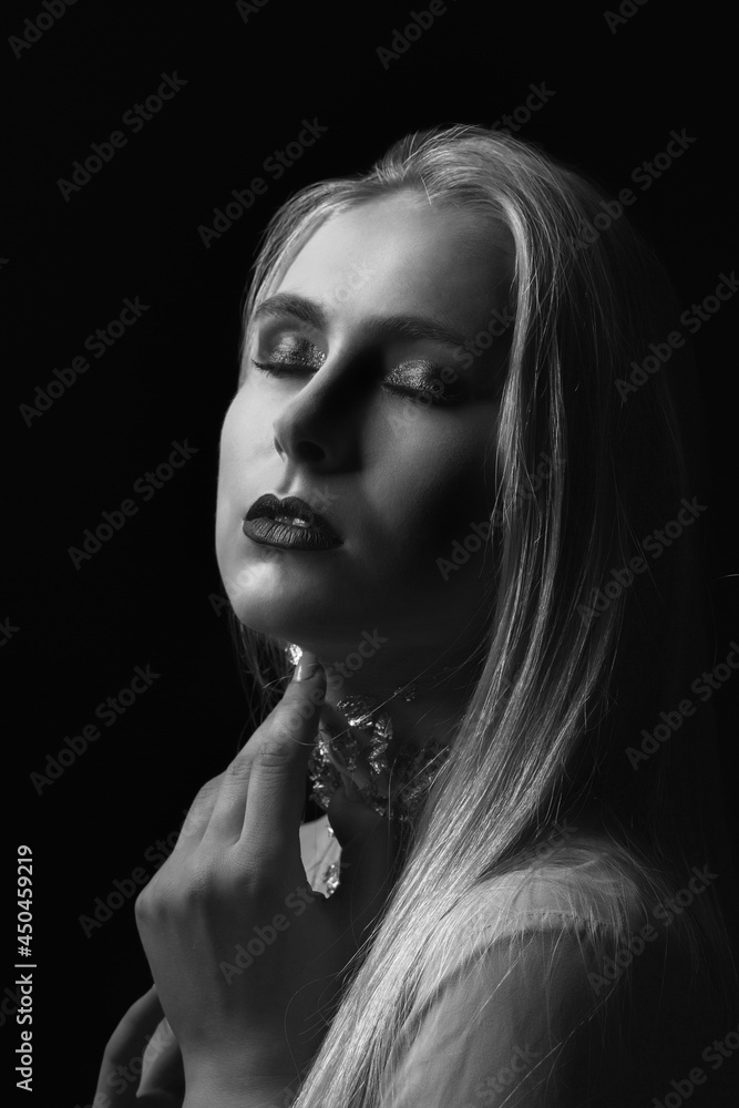 Tender young lady posing in the shadow with foil on her neck Tender young lady posing in the shadow with foil on her neck