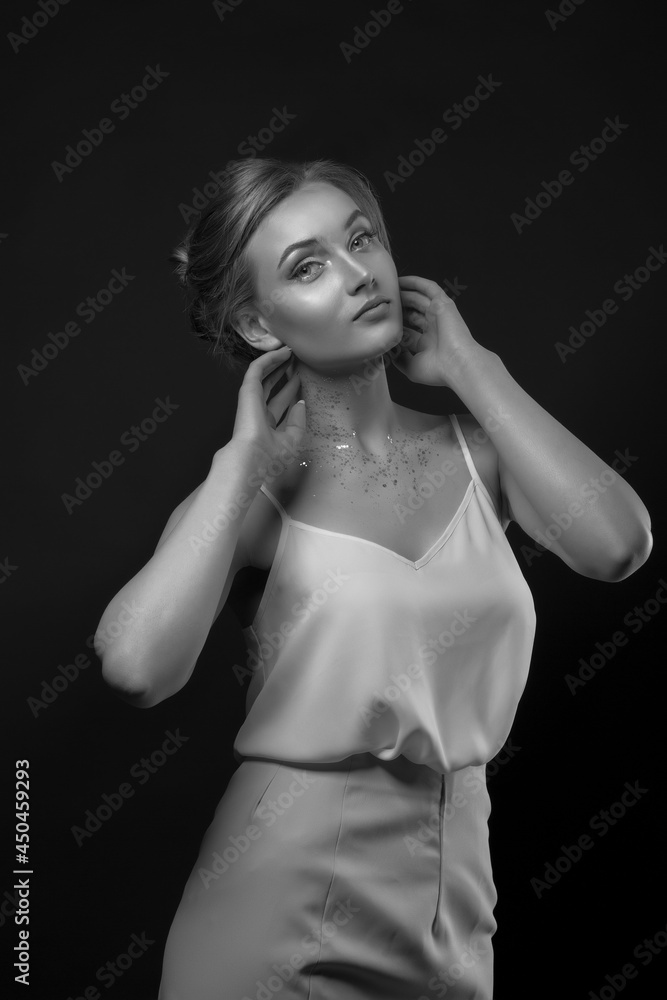 Fashionable blond lady wears white silk dress posing in the shadow at studio Fashionable blond lady wears white silk dress posing in the shadow at studio
