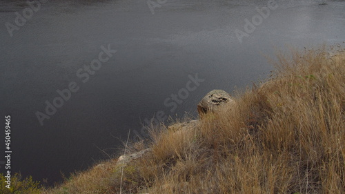 Sucha trawa i kamienie na tle wody, Zaporoże, Ukraina