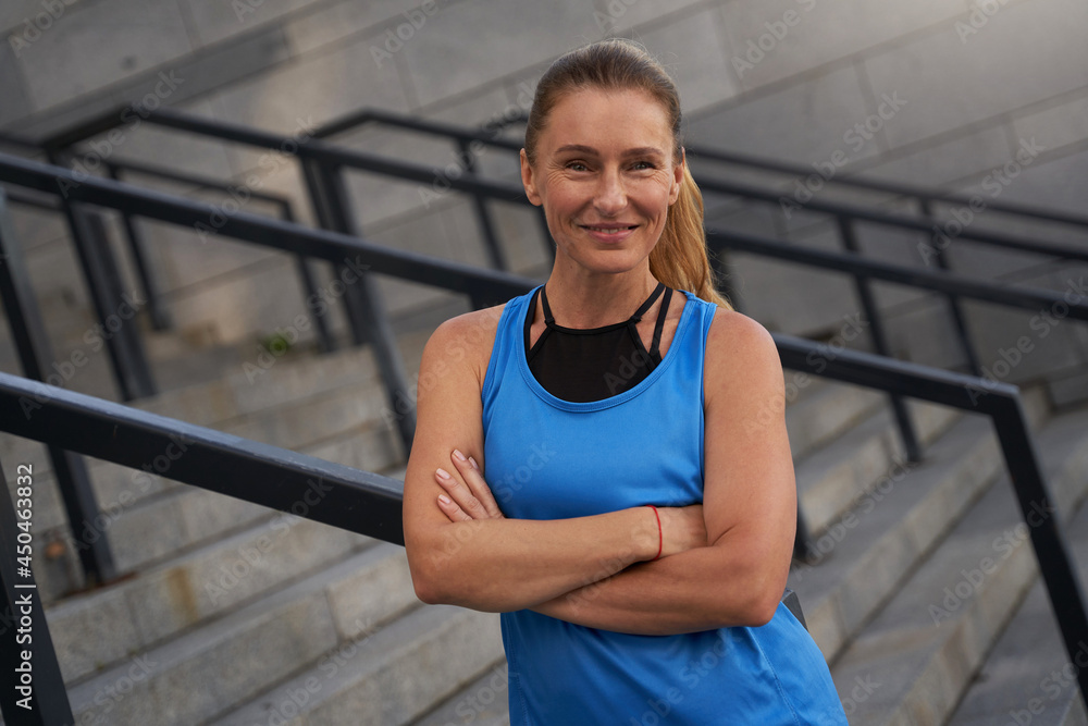 Portrait of smiling mature woman in sportswear posing outdoors after training in the city Portrait of smiling mature woman in sportswear posing outdoors after training in the city