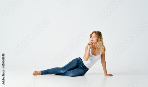 woman in t-shirt lies on the floor lifestyle studio isolated background
