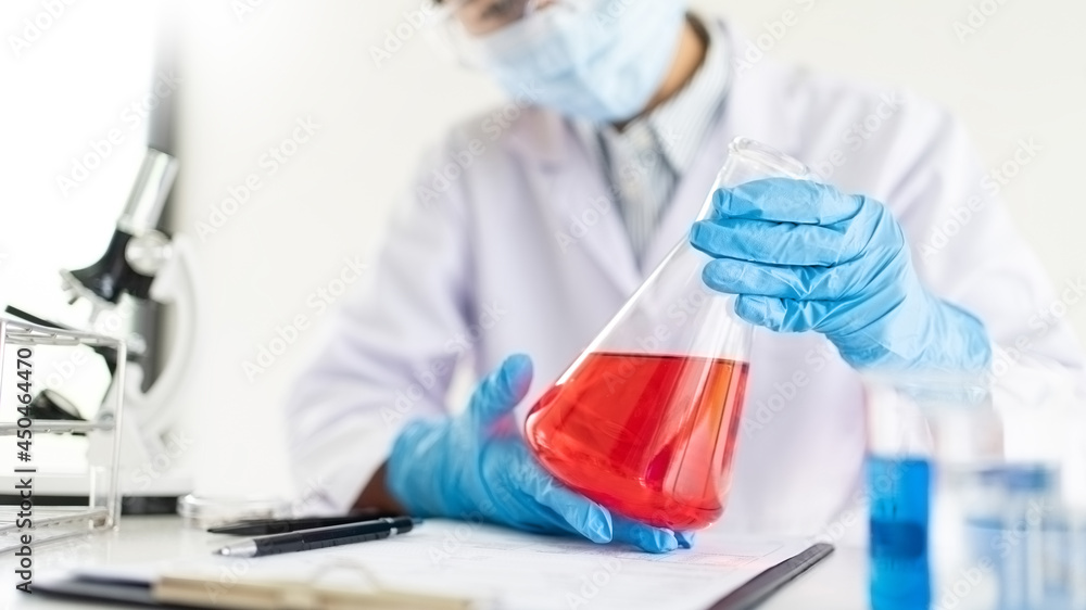 Fototapeta premium scientists researching in laboratory in white lab coat, gloves analysing, looking at test tubes sample, biotechnology concept