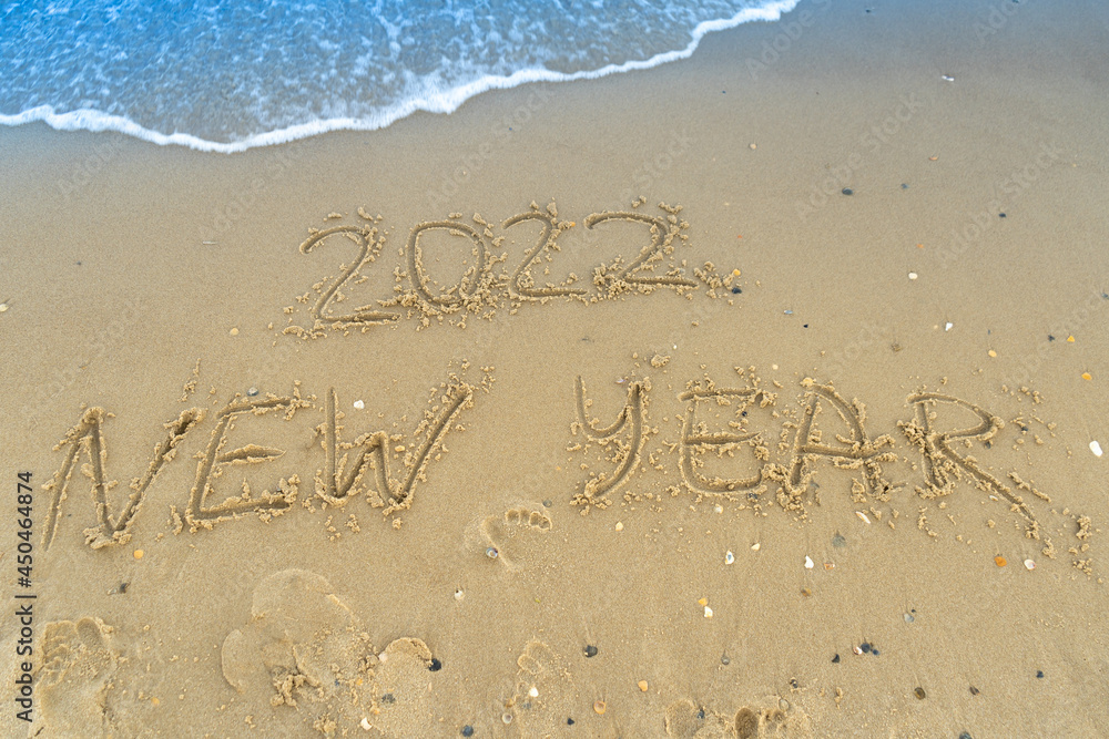 Fototapeta premium The numbers 2022 are written on a sandy seashell beach. Wave and surf. Summer New Year 2022. Vacation, resort and recreation. Nature. Sea coast