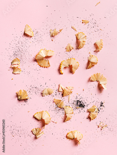 Close up of graphite pencil waste isolated on a pastel pink background. Creative back to school concept. Homework time or drawing activity. Flat lay, top view.