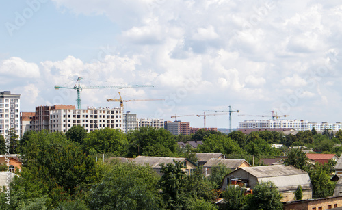 Skyline with new skyscrapers under construction. View of the cityscape with multi-storey residential buildings, houses under construction.