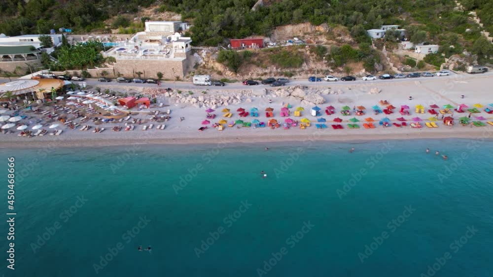 Beautiful beach with bars and umbrellas near turquoise sea water in Mediterranean coast of Albania Beautiful beach with bars and umbrellas near turquoise sea water in Mediterranean coast of Albania