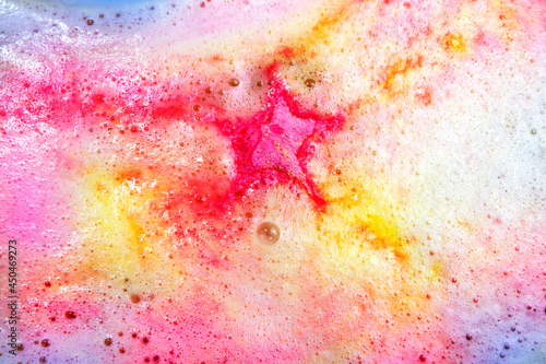 Dissolving color bath bomb in water, closeup.