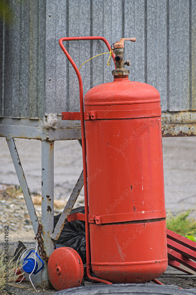 A large fire extinguisher in a small parking lot
