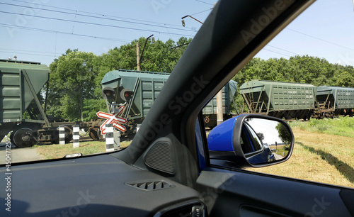 Obraz na plátně Closed Level Crossing With Moving Train View From Waiting Car