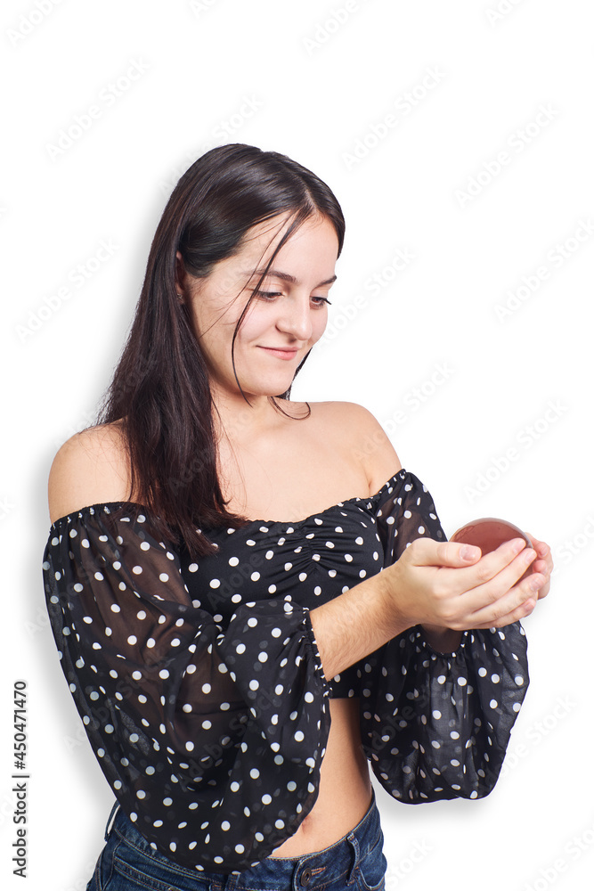 Hispanic teenage girl playing with crystal ball on white background. Mysticism concept