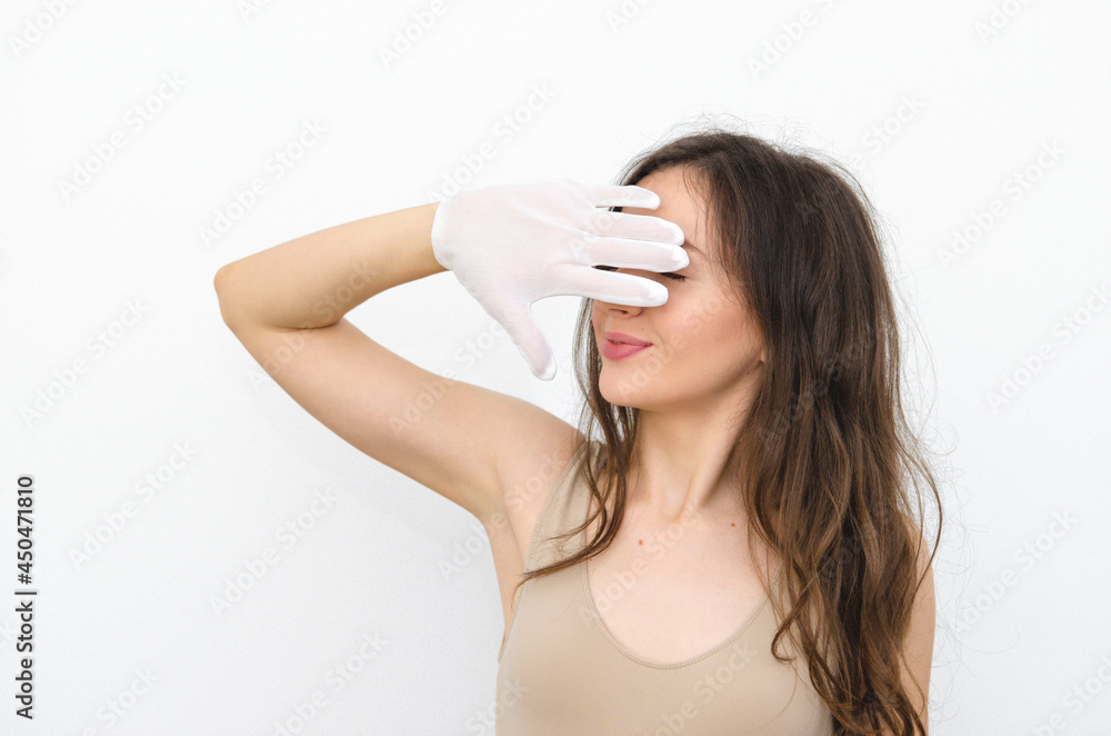 young woman brunette closed her eyes with a hand in a white glove young woman brunette closed her eyes with a hand in a white glove