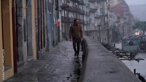Wallpaper Mural A man walks in the narrow Ribeira street dear the Douro river on a foggy morning Torontodigital.ca