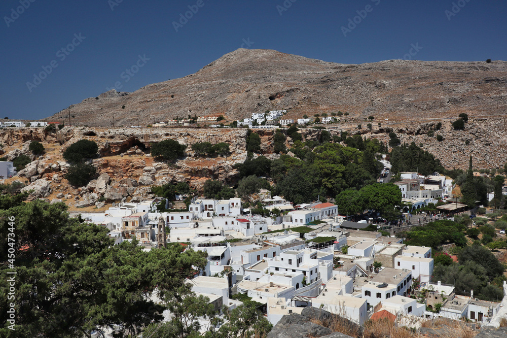 Lindos Village with White Houses and Hill during Beautiful Day in Rhodes. Touristic Greek Village with Blue Sky in Greece.