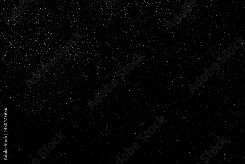 Falling snow on a black background. small particles with bright dots starry sky. Сhaotic white bokeh. light spots texture. abstract.