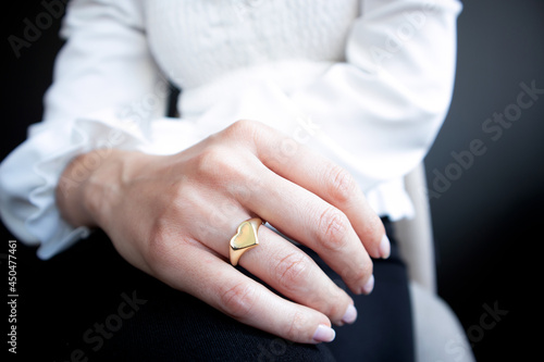 Woman jewelery concept. Woman’s hands close up with jewelry rings. Heart shaped gold ring for girlfriend on valentine’s day. Selective focus
