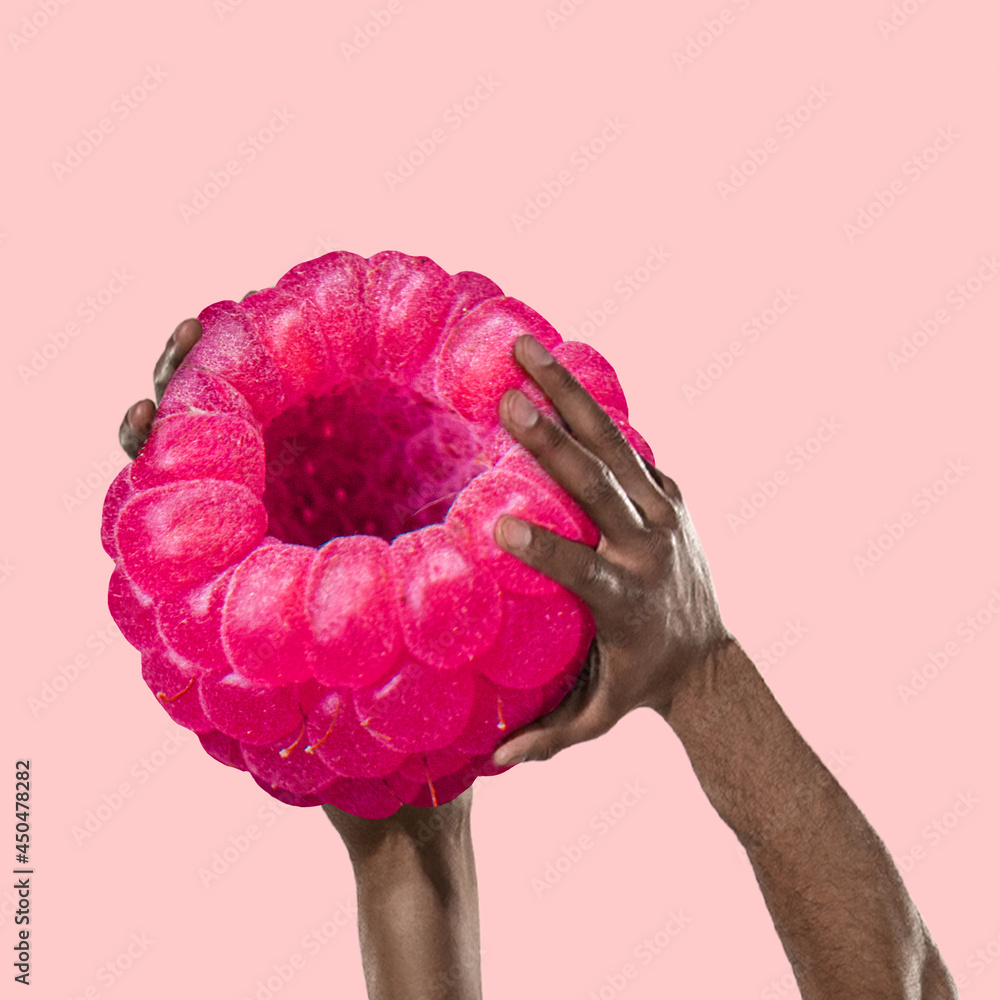 Fototapeta Composition with huge raspberry and human strong hands holding it. Healthy eating concept. Art collage
